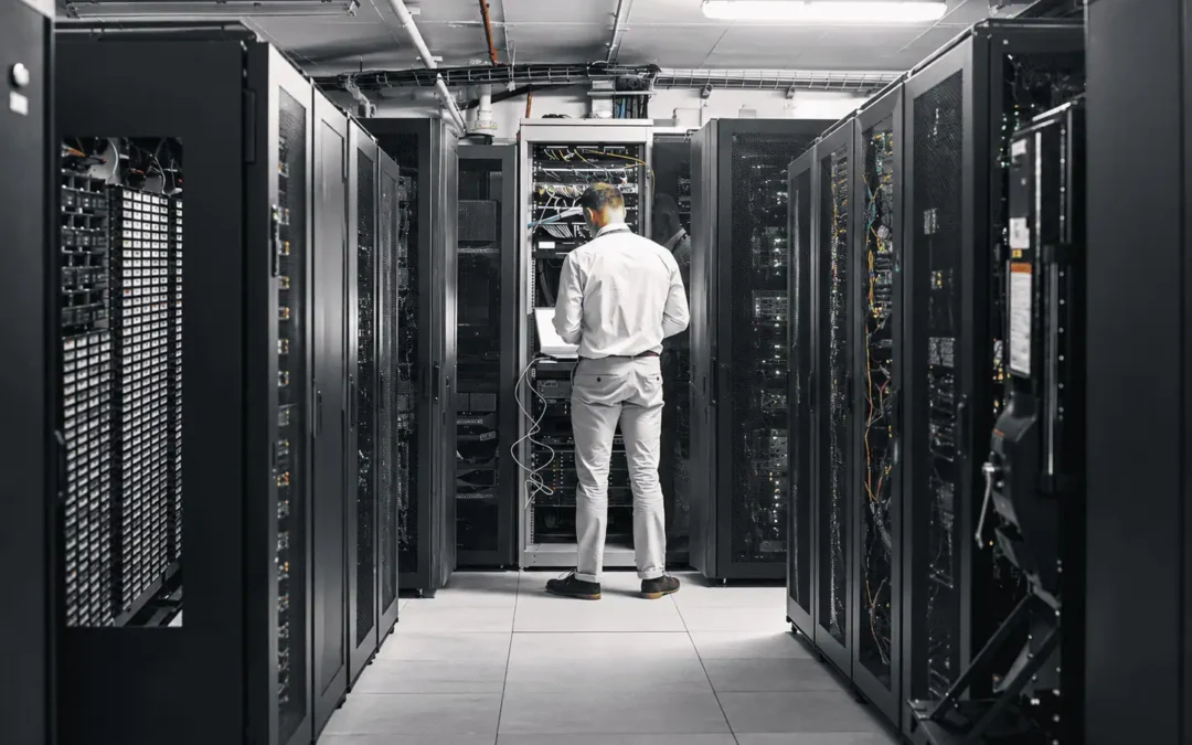 Technician working between rows of server racks in a data center.